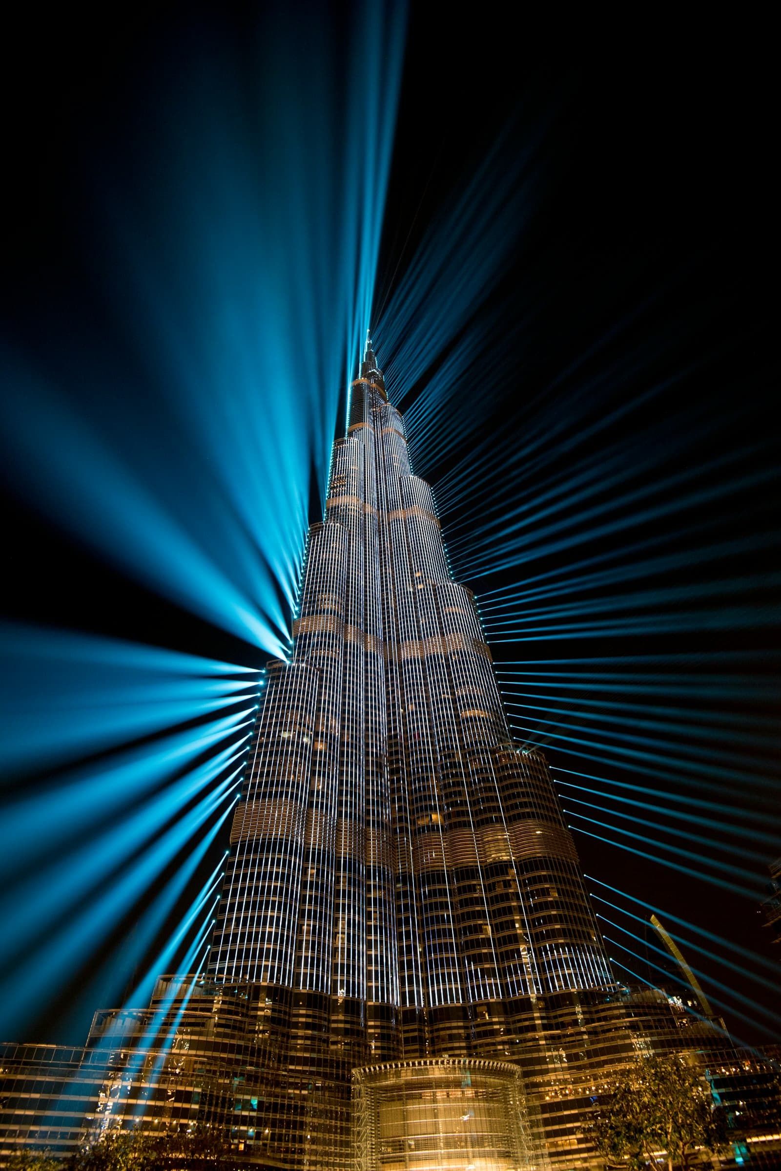 Burj Khalifa illuminated at night with light beams across the sky