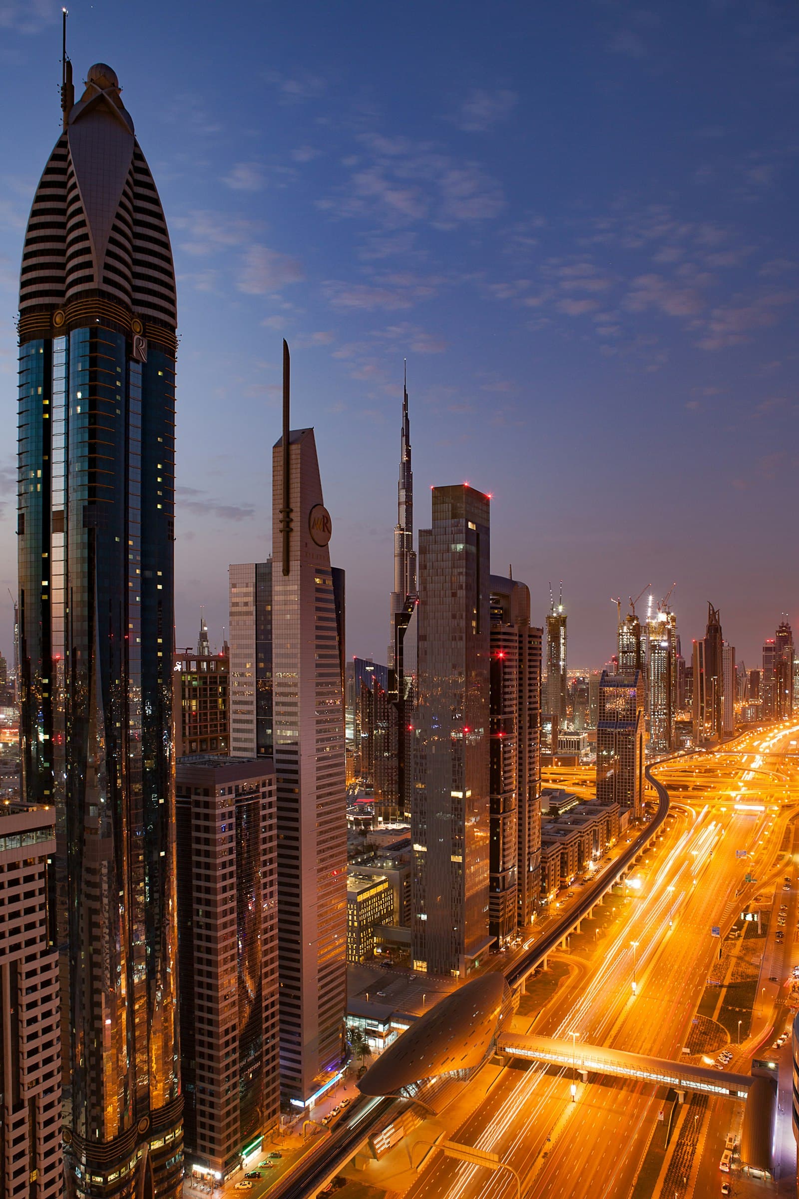Illuminated Dubai towers rising at dusk, the skyline destined to be rivalled by Dubai Creek Harbour